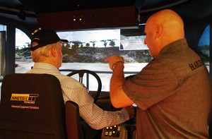 Bill Bennett takes his turn behind the wheel of the simulator, with Instructor Darren Hood providing guidance.