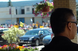 One of Premier Clark's RCMP security agents surveys demonstrators in front of the Heritage Inn prior to the luncheon.