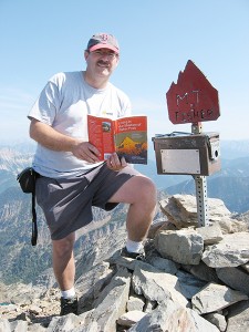 Author Keith G. Powell at the summit of Mt Fisher with his first book, Living in the Shadow of Fisher Peak