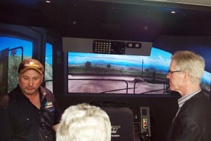 COTR lead haul truck simulator trainer Darren Hood, left,  walks City of Kimberley Mayor Don McCormick, right, and City of Cranbrook Mayor Lee Pratt (centre) through the Haul Truck Simulator, available for funding ceremony participants to check out Tuesday afternoon.