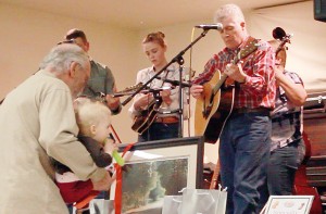 Sagegrass donating time and talents to entertain all, including raffle customers (foreground).