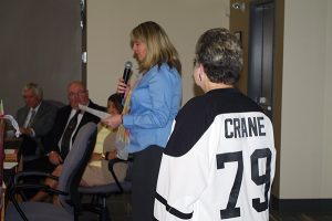Lee-Ann Crane, a major hockey fan (Montreal Canadiens and Kootenay ICE), wearing a symbolic captain's jersey, listens to Area F's Wendy Booth address the boardroom.