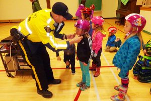 Cst Scott Payne, Kimberley RCMP assisting students at Lindsay Park Elementary School with bicycle safety and helmet fit.