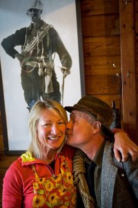 Chef Kelly Mager gets a smooch from Mountain WIT actor David Thomson who embodies Kain's gregarious quick wit in a performance at the Conrad Kain hut. Photo by Pat Morrow